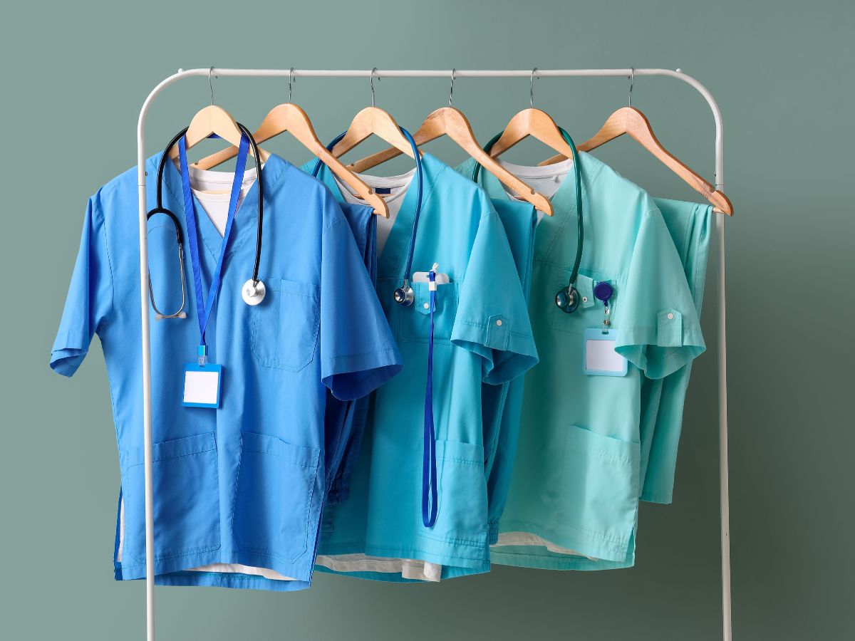 Medical scrubs hanging on a rack in gradient blue tones