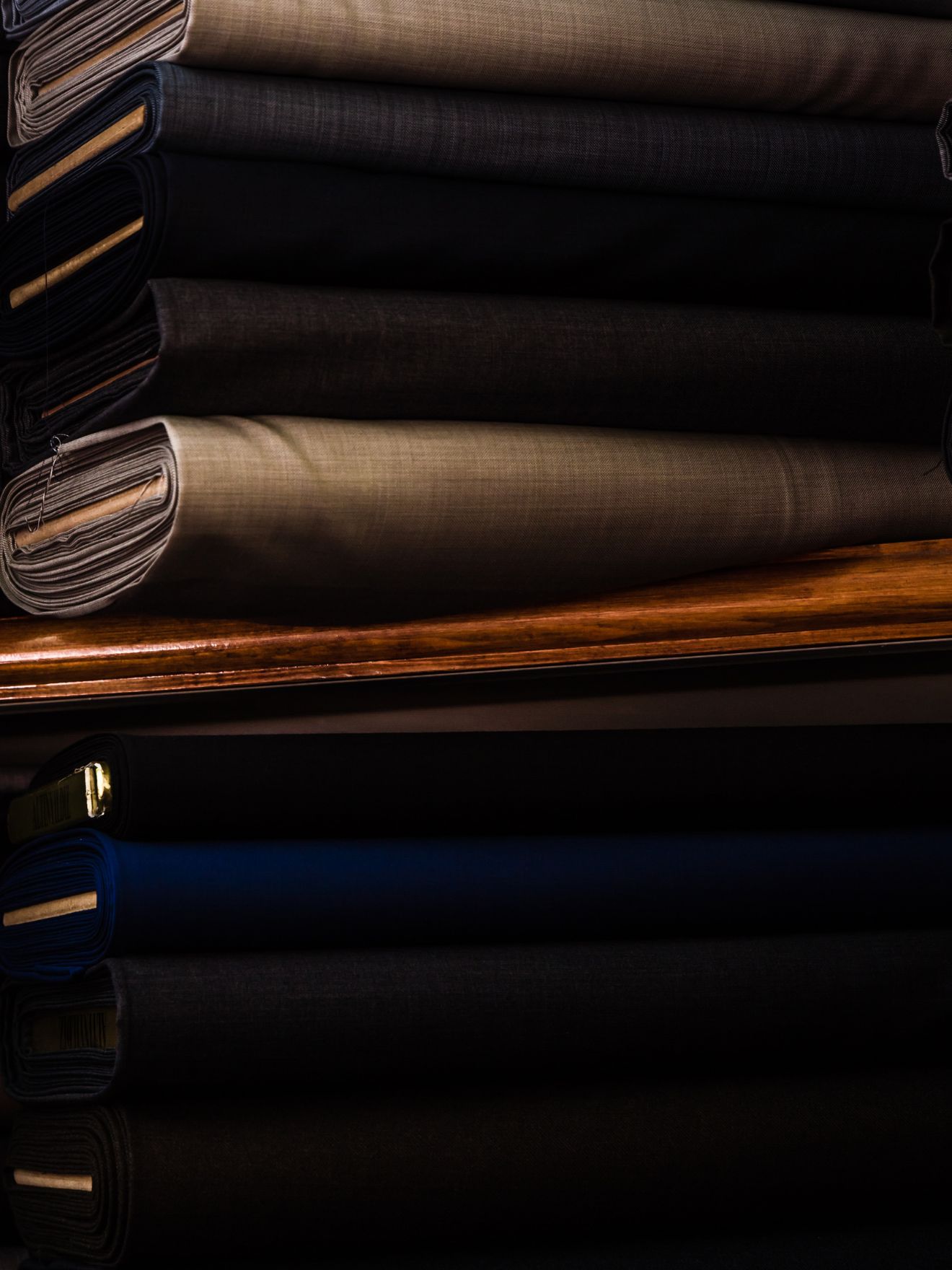 Premium suiting fabric rolls stacked on shelves